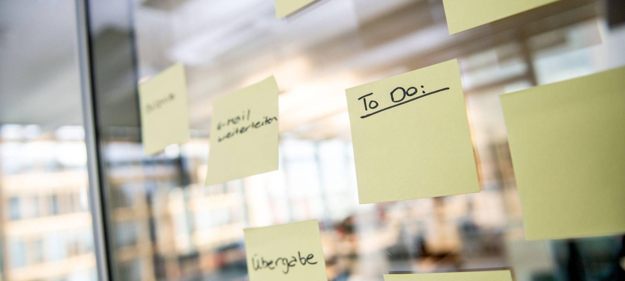 Notizzettel mit den Worten To Do kleben in einer Scheibe im Büro