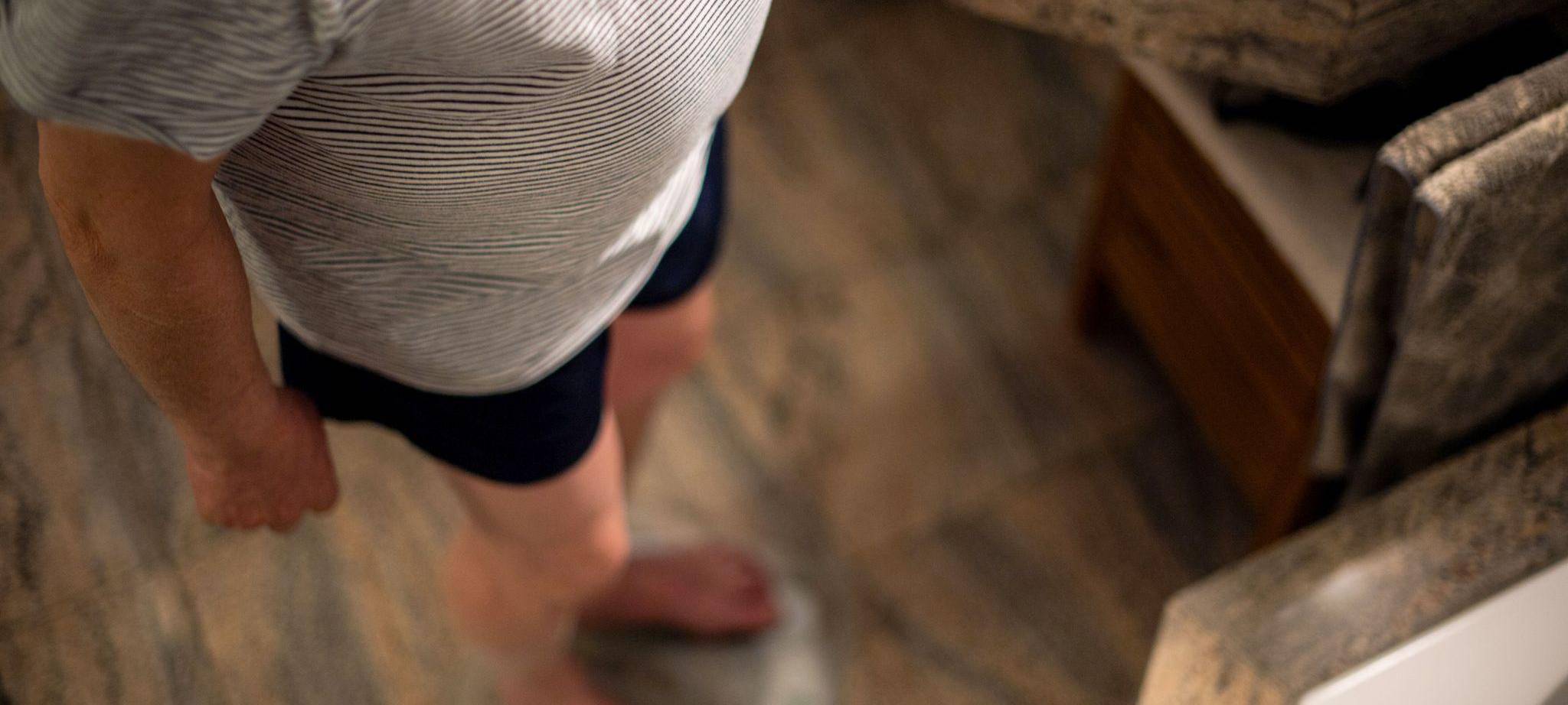 Ein Mann steht im Pyjama auf der Waage