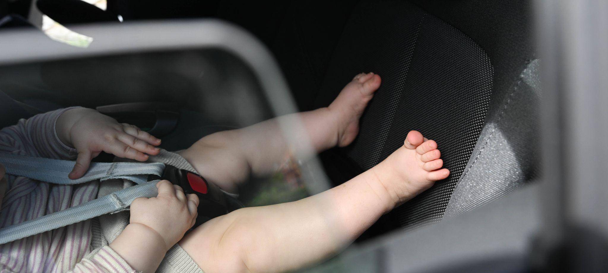 Baby liegt in einer Babyschale im Auto
