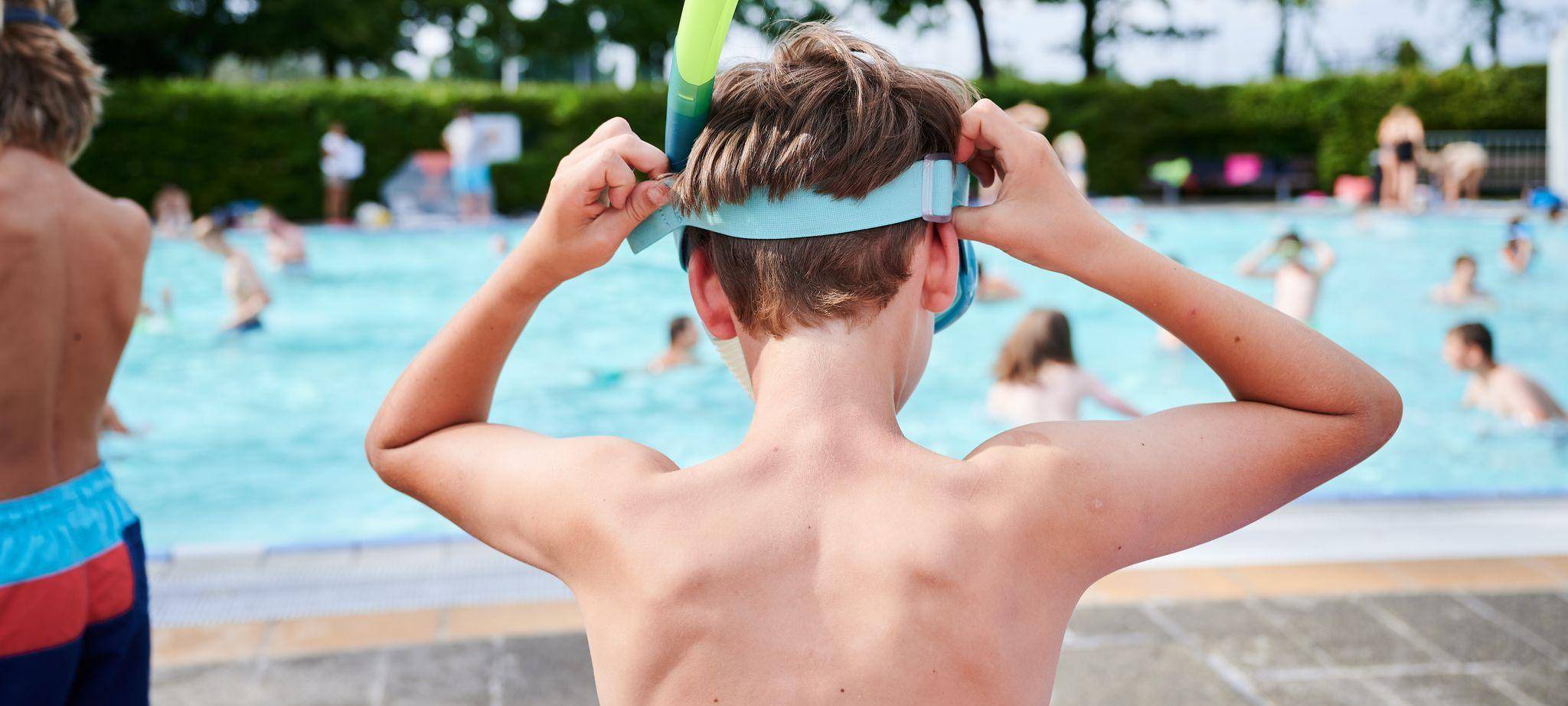 Kind setzt sich seine Taucherbrille auf